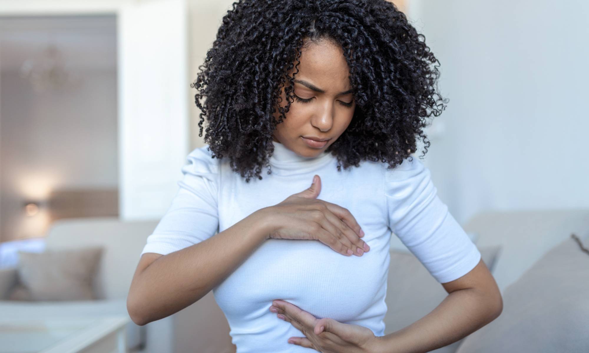 Woman palpating her breast for preventive care Woman palpating her breast for preventive care